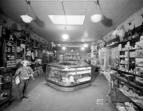 Interior of Felton Gun Store, located at 120 E. Washington Avenue, with elk, deer, and mountain goat heads mounted on the wall among the firearms and hunting and fishing gear.