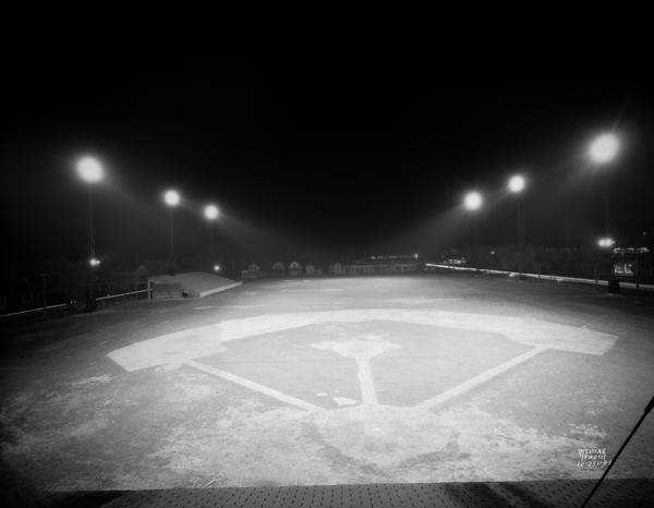 Elevated view of the Breese Stevens Athletic Field baseball diamond illuminated at night.