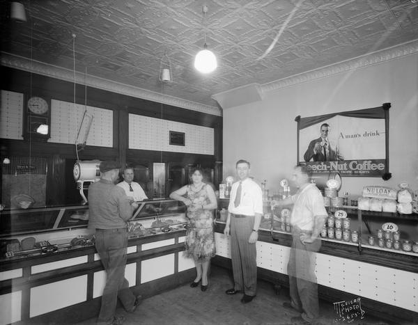 Fair Oaks Market interior, with meat counter and other food products, butcher and customers. August F. Schulz was the manager of the store.