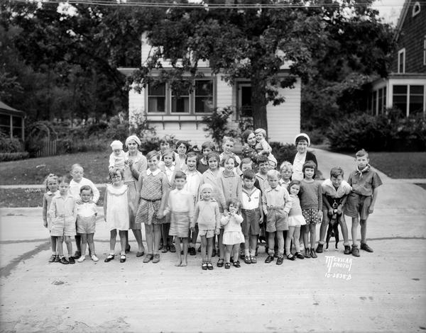 Group portrait of mothers and children in front of a house at 434 Virginia Terrace.
