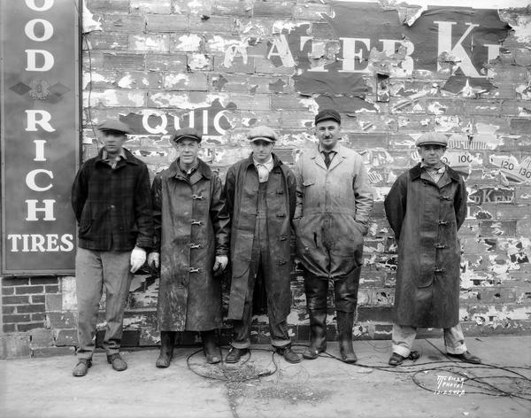Group portrait of five fire fighters after their rescue from the blazing roof of the building that was burned in the fire. From left to right, they are E.A. Lins, K. Wilkinson, D.C. Williams, H.H. Lins, and C.J. Johnson.