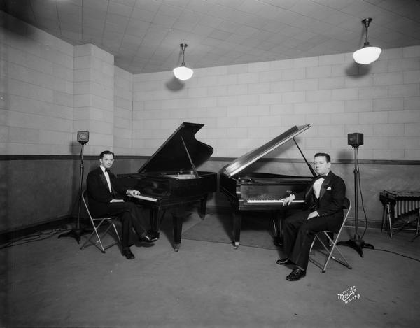 Tuxedo-clad pianists sitting at twin Baldwin grand pianos in a WIBA studio.
