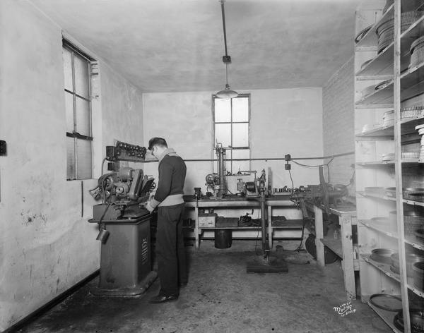 A machinist working at the Charles H. Halperin machine shop, located at 209 S. Park Street.