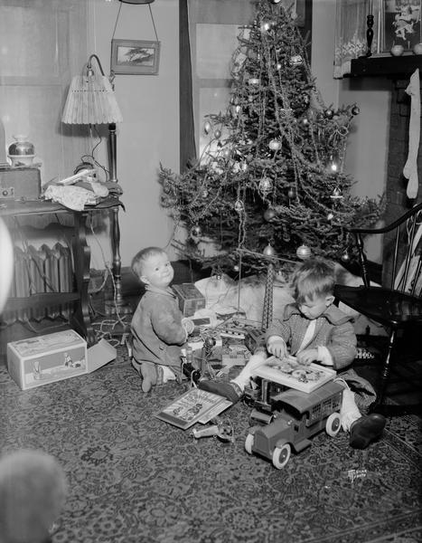 Malcolm (left) and Richard McVicar playing with their new toys (including a toy truck) in front of the tree on Christmas morning.