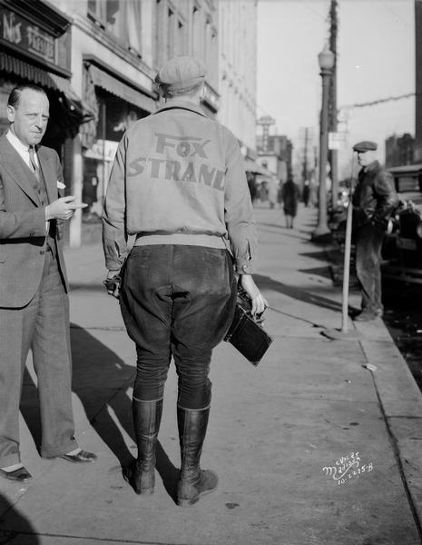 Charles Loewenberg, manager of the Strand Theatre, and Aldro Wasley, photographer, wearing a Strand jacket and jodhpurs, standing on E. Mifflin Street.
