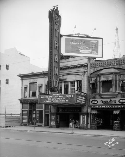 Strand Theater, with marquee advertising Warner Baxter and Carol Lombard in "The Arizona Kid," and Collyer's Pharmacy, Kinney Shoes, and a Heinz billboard.
