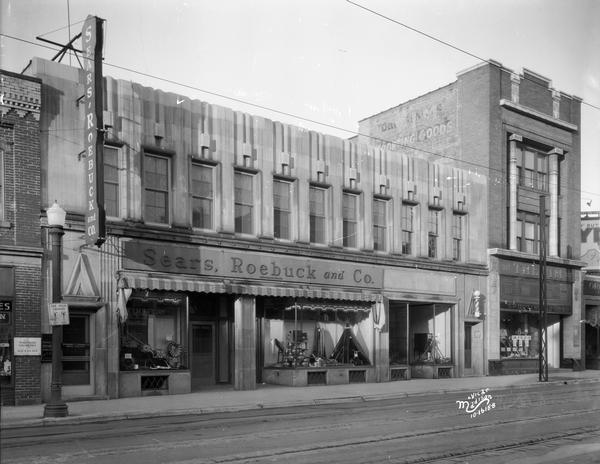 Sears Roebuck and Company store, 313-315 State Street, and The Vim sporting goods store, 317 State Street, with a sign painted on the side of its building.