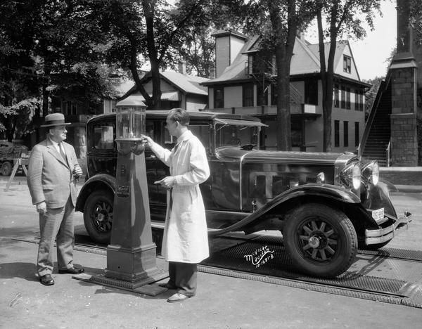 Mr. Trostle gets his brakes tested by a Weaver Automatic Brake Tester in the "Safety Lane" on Wisconsin Avenue, sponsored by the American Automobile Association (AAA).