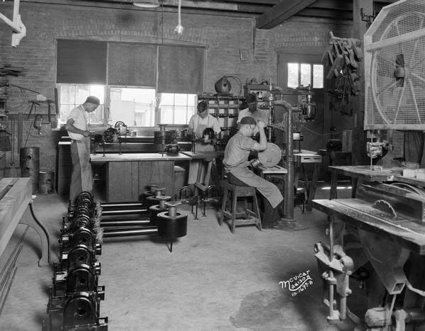 Employees of the Bock Oil Burner Company work in the machine shop.