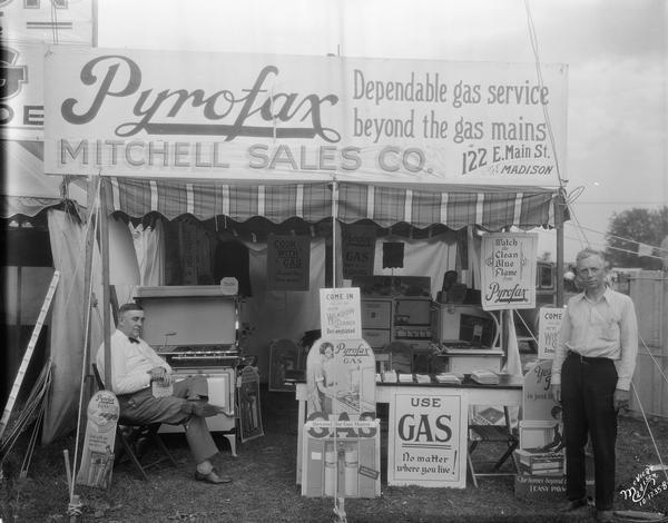 Two salesmen posing in the Pyrofax gas appliance booth at the Dane County Fair.