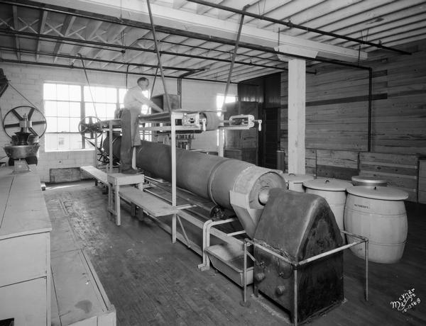 A man operates baking and drying machinery at the Floralo Incense Company, located at 1212 Regent Street.