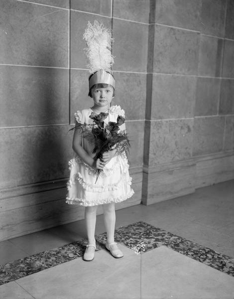 Five-year-old Betty Livesey pauses for a picture after the "Declaration of Chivalry" ceremony conducted at the 81st annual Capitol Grand Encampment of the Capitol Wisconsin I.O.O.F. Independent Order of Odd Fellows. The encampment was held in the Capitol building on October 9th, 1928. Betty was the daughter of Russell Livesey, Captain of the Four Lakes Canton. Betty Livesey Maffet passed away at the age of 75 on September 28th, 1998.