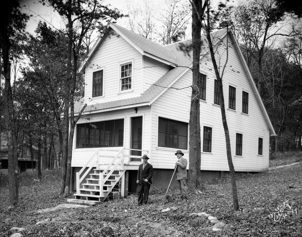 Two men are standing with shovels outside the Kilowatt Clubhouse, 5311 Tonyawatha Trail, on Lake Monona. It became the home of Fred Rasmussen.