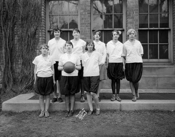 Outdoor group portrait of the Central High School 11A girls' basketball team. They are wearing bloomers.