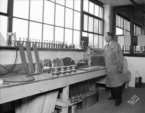 Chemist at workbench at the Mautz Paint & Glass Company, 939 E. Washington Avenue.