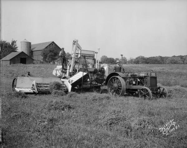 Two men on a Nichols & Shepard combine thresher and Hart Parr tractor.