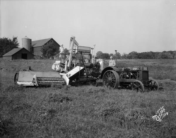 Two women on a Nichols & Shepard combine thresher and Hart Parr tractor.