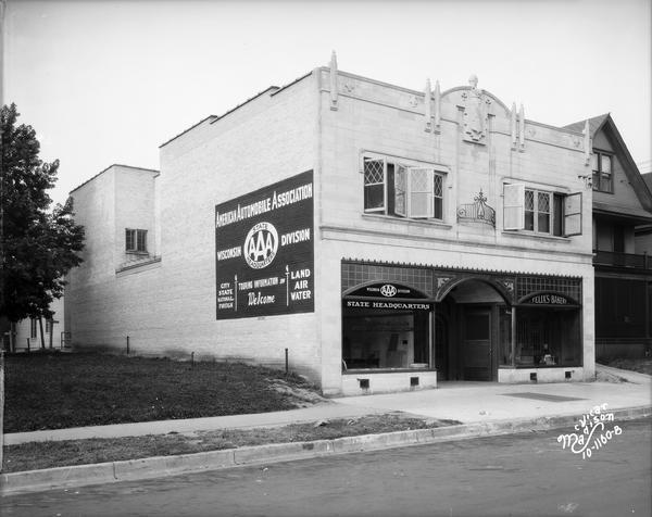 View across street towards the Madison Auto Club (AAA) with AAA sign painted on side of building and Felix's Bakery, owned by Felix Odehnal, located at 715 University Avenue.