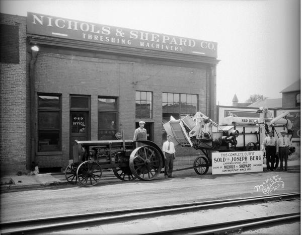 Nichols-Shepard Company store, located at 649 E. Mifflin Street, with men, tractor and threshing machine in front. Large sign in front reads: "This complete outfit sold to Joseph Berg Campbellsport Wisconsin users of Nichols & Shepard machinery continuously since 1882."