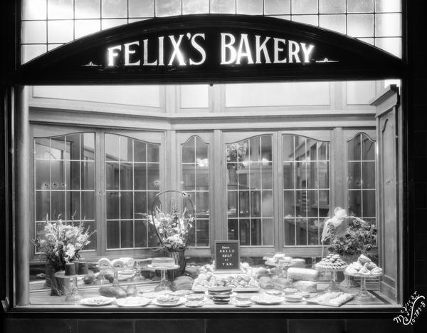 Night view of pastries in the display window at Felix's Bakery, owned by Felix Odehnal, at 715 University Avenue.