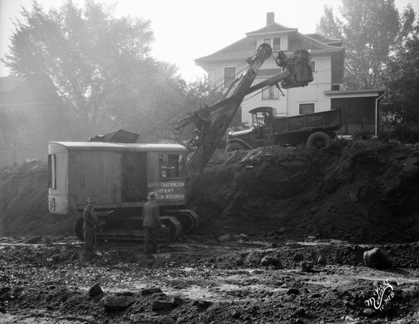 Quinn Construction Company steam shovel excavating for the First Congregational Church, 1609 University Avenue. There is a house in the background.