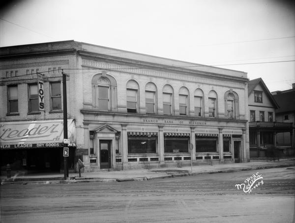 View from Wolff-Kubly & Hirsig corner towards the Branch Bank of Wisconsin located at 502 State Street, and the Leader Dry Goods Store on the left.