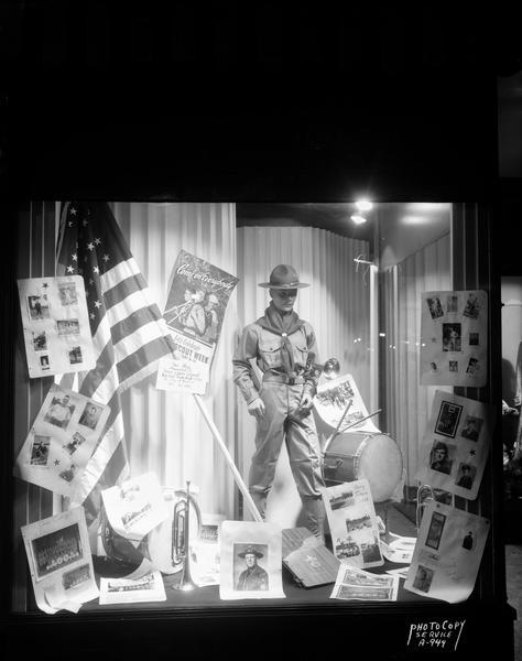 Karsten's Men's & Children's Clothing Store, 24 North Carroll Street, display window featuring a mannequin dressed in a Boy Scout uniform and posters with photos of Boy Scouts troops and activities in celebration of National Boy Scout Week.
