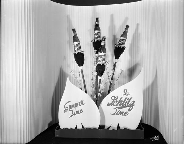 Schlitz display with four bottles of beer displayed as flowers with sign "Summer Time is Schlitz Time."