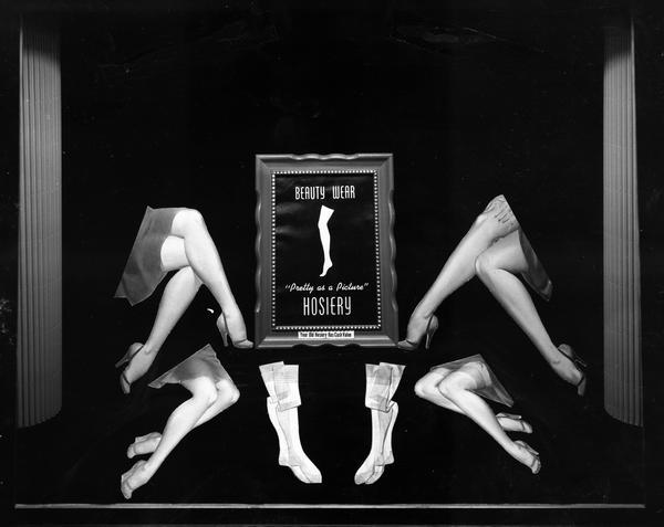 Window display for Beauty Wear Hosiery stockings, with sign in picture frame that reads: "Beauty Wear, Pretty as a Picture HOSIERY, Your Old Hosiery Has Cash Value."