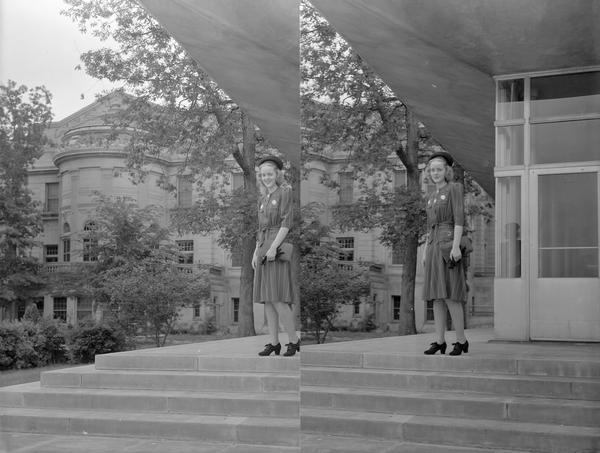 Manchester's Department Store coed model, wearing dress hat and purse, posing in front of the Memorial Union on University of Wisconsin-Madison campus.