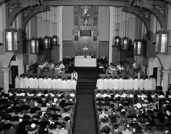 Bethel Lutheran Church, located at 318 Wisconsin Avenue. Confirmation class standing in the chancel area congregation, with the choir and ministers visible.