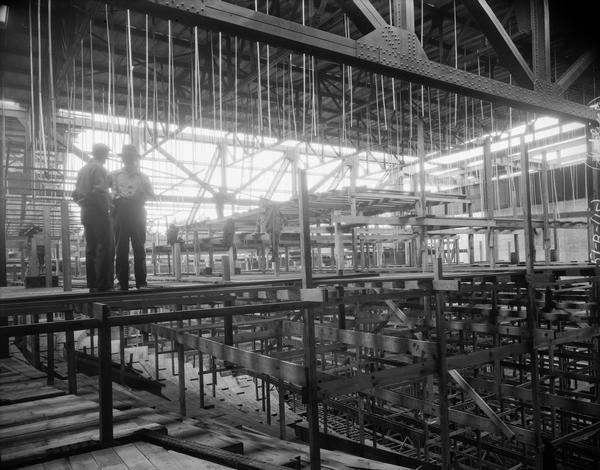 Orpheum Theatre under construction, located at 216 State Street, from upper balcony with two men standing on the scaffolding on the left.