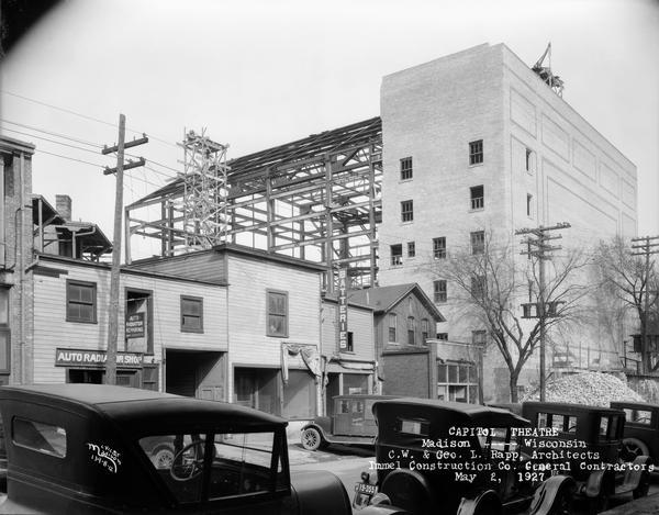 View of Madison businesses on Henry Street, with steel frame construction of the Capitol Theatre in the background.