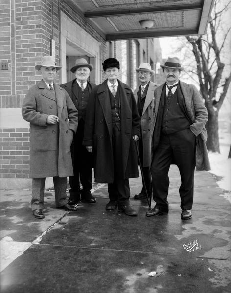 Five men who were active in the Progressive Movement are standing in front of the Capital Times building, 302 East Washington Avenue. L to R: Louis Davlin, Berlin; Assemblyman J.C. Hanson; Newcomb Spoor; Assemblyman Ray Lawton; and Assemblyman John Gamper.