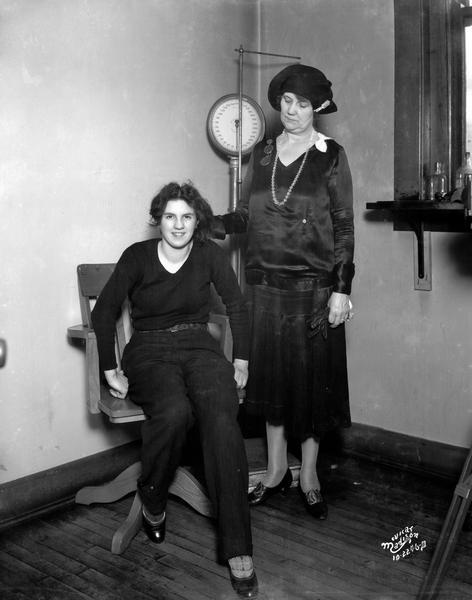 Lillian Rice (aka Loretta La Boze), 18 of Janesville, in man's clothing with police matron, Pearl Shaughnessy, at the Police Station. Lillian was arrested for trying to "flip a freight" train.