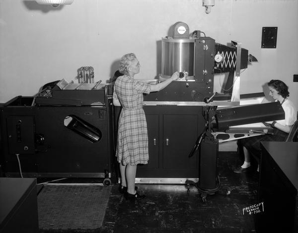 Two women operating a Duplex Rectigraph machine at the Dane County Court House, located at 207 Main Street.