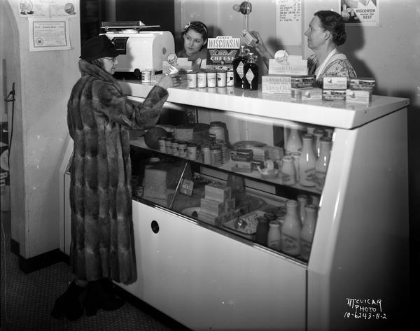 Two clerks and a customer in McCoy's Ice Cream Shop, located at 507 State Street. Prominent in the view is a Oscar Mayer Coolerator food display case.