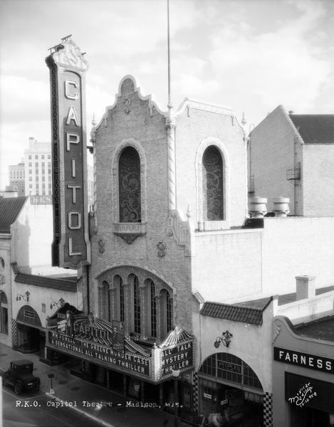 Elevated view of the Capitol theatre tower and marquee (209 State Street) with Kessenich's (201 State Street), Fred W. Kruse Co (205 State Street), Peoples Clothing Company (213 State) and Farness Furniture (215 State Street). Marquee reads: "William Powell in the Greene Murder Case, a sensational all talking mystery thriller."