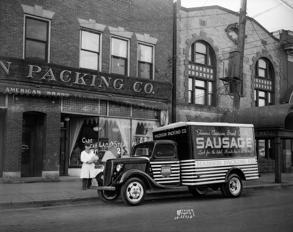 Madison Packing Co. (Neesvig) truck parked in front of their store at 307 W. Johnson Street, with Labor Temple next door, 309 W. Johnson Street. Sign on truck says: "Famous American brand quality sausage."