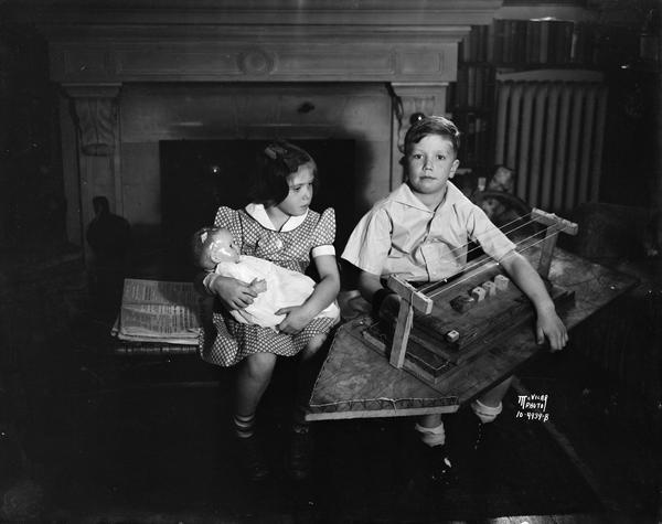 Robert La Follette, 8, holding large wooden boat, and Judy La Follette, 5, holding a doll. They are the children of Governor-elect Phillip La Follette and Isabel La Follette.