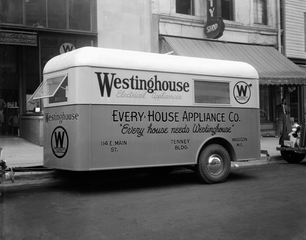 Every-House Appliance Co. trailer with a sign that reads: "Every house needs Westinghouse," 114 E. Main Street.