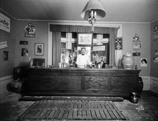 Bar set up for informal party at Phi Epsilon Pi fraternity house with beer keg and beer advertising on the wall. There is an autographed picture of Rudy Vallee on wall.