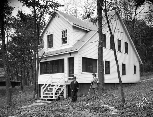 Two men are standing in front of the Kilowatt Clubhouse, 5311 Tonyawatha Trail, Monona, on the shore of Lake Monona. It became the home of Fred Rasmussen.