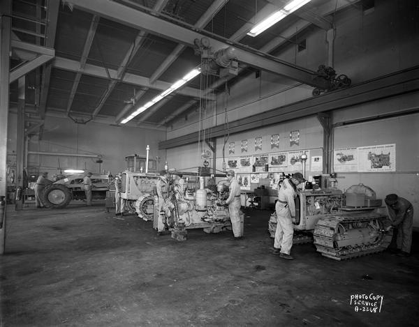 Nagle-Hart Tractor Company, 212 South Thornton Avenue. Repair shop showing several pieces of Caterpillar equipment being repaired by mechanics.