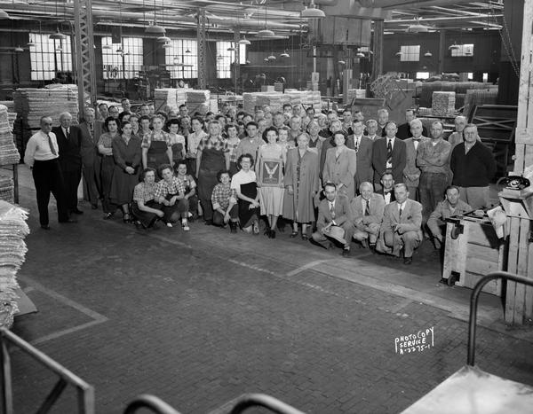Group portrait of Research Products employees on the factory floor, 1011-1015 East Washington Avenue, having received the National Safety Council Award for the Paper Industry Safety Contest.
