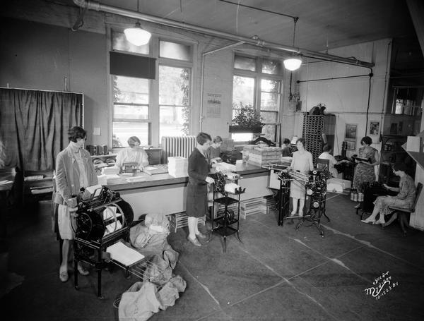 Nine women working in General Laboratories mailing and filing room, located at 124 South Dickinson Street.