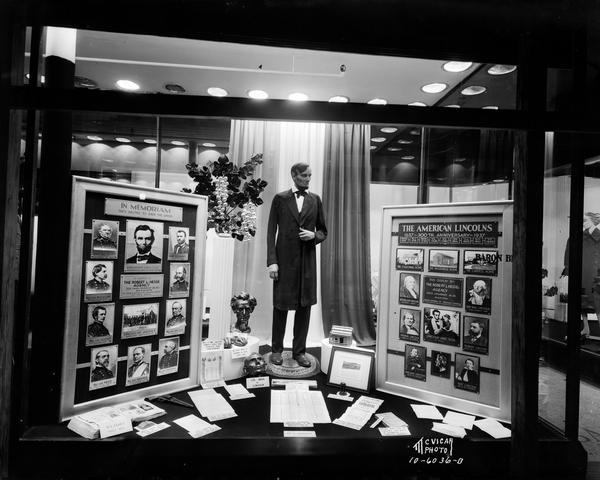 Abe Lincoln window display at Baron's taken for Robert L. Hess Agency of Lincoln National Life Insurance Company. Posters with photographs and other memorabilia honor the 300th anniversary of the Lincoln family in the United States.