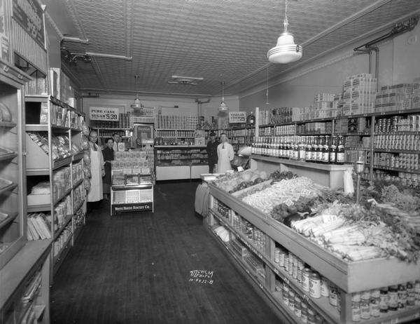 Miller Grocery Store, located at 113 North Hamilton Street. The interior of the store has food displays and shelving, and five people are standing in the background.
