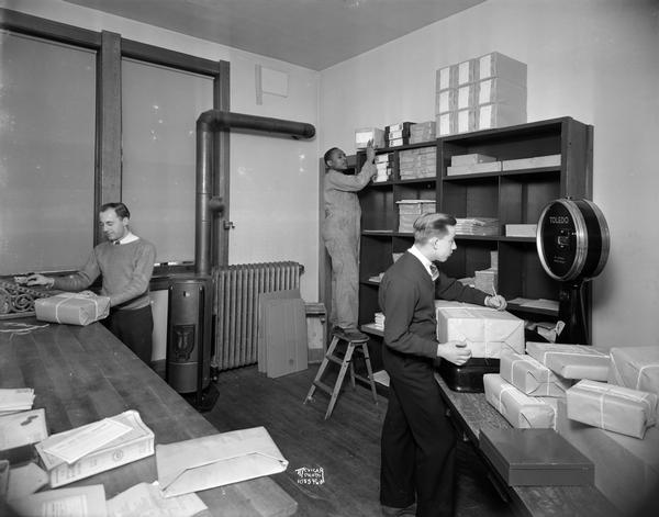 Three men in CUNA (Credit Union National Association) mailing room, Raiffeisen House, located at 142 East Gilman Street.
