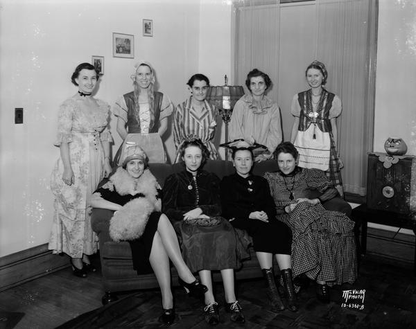 Group portrait of nine women posing indoors in Halloween costumes. 119 N. Butler Street.